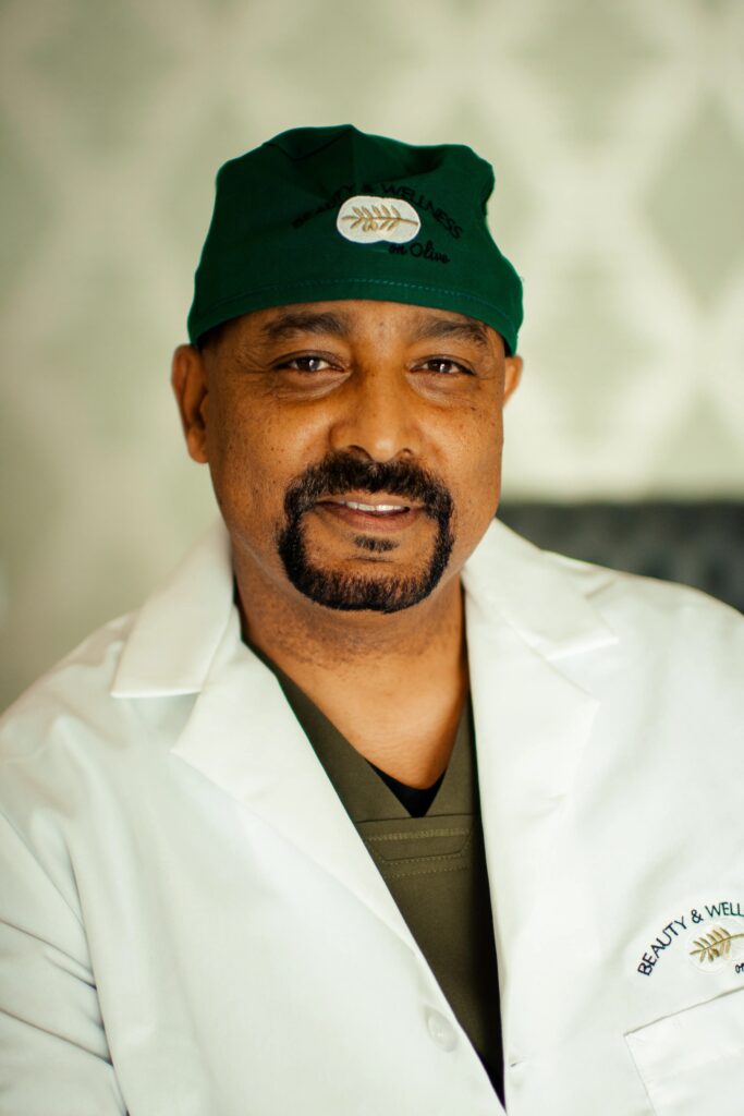 A man in white lab coat and green hat.