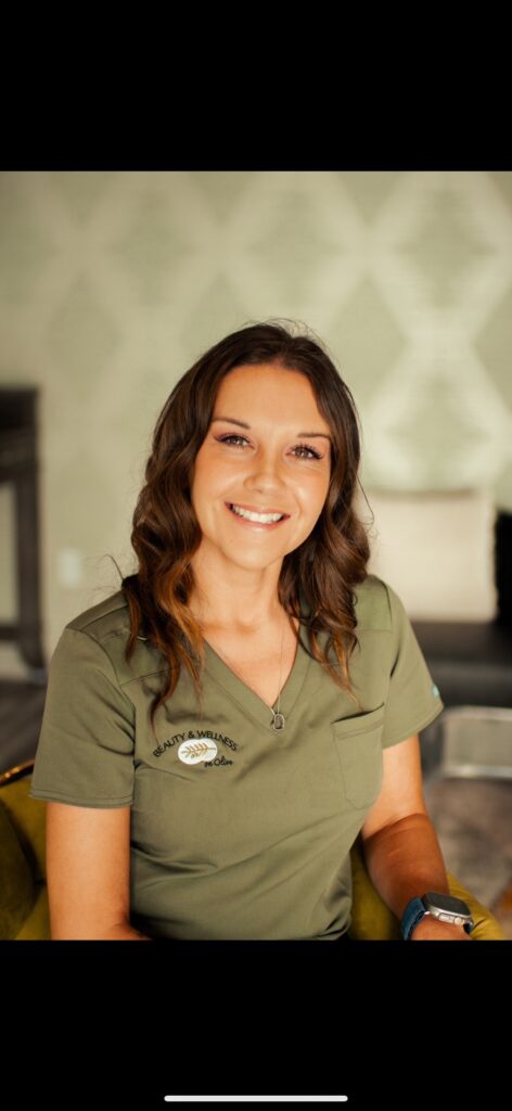A woman in green shirt smiling for the camera.