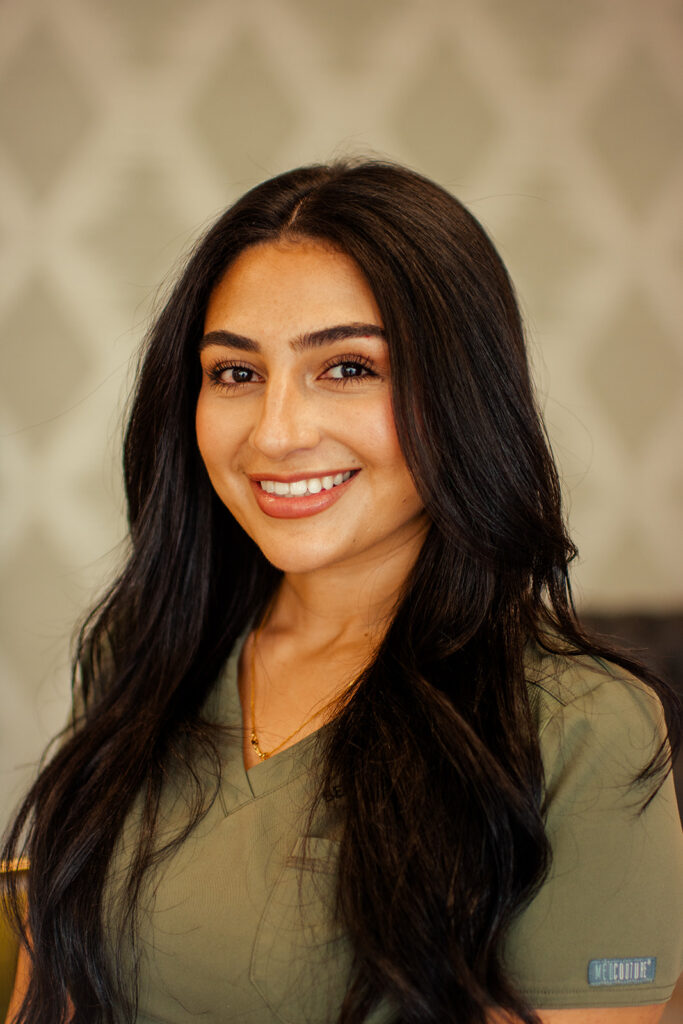 A woman with long black hair smiles for the camera.